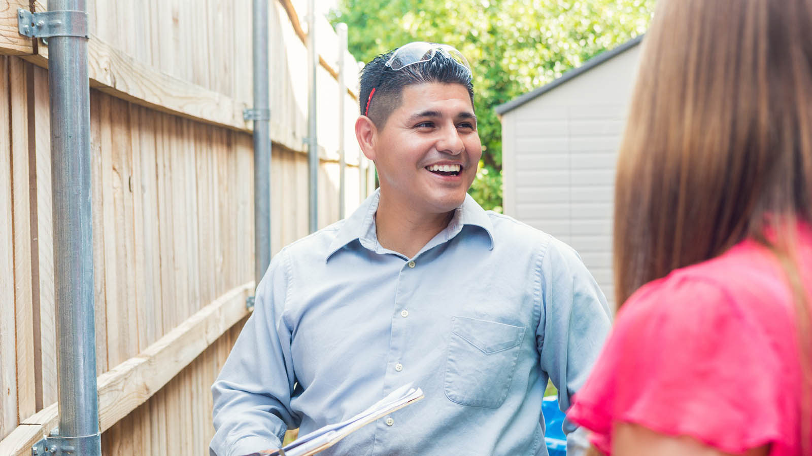 An inspector discussing a timber fence installation with the home owner.