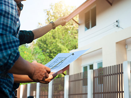 An inspector and contractor reviewing house plans.