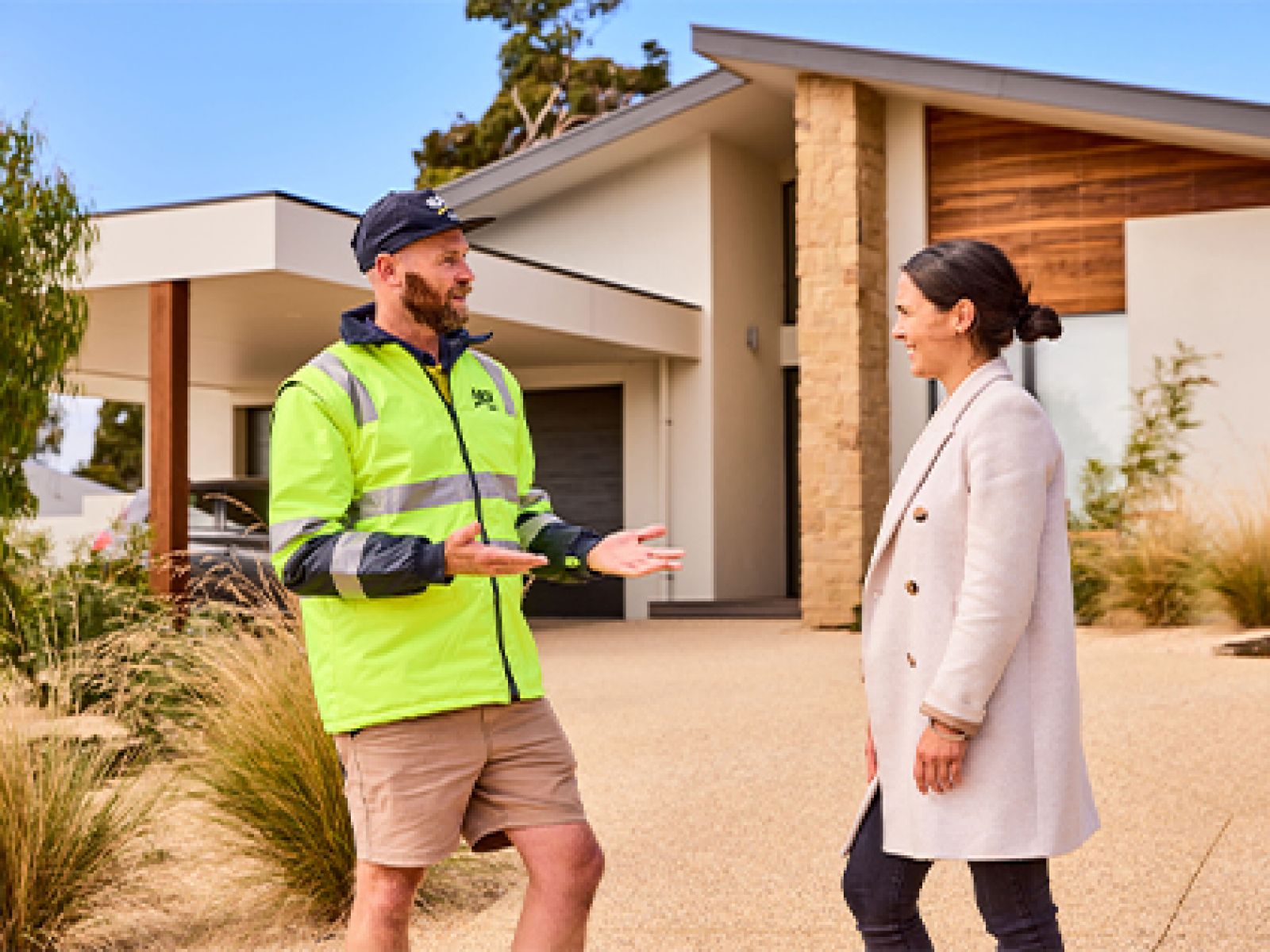Two people discussing trades outside a home