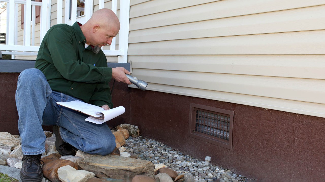 home-inspection-foundation-1600x900.jpg An inspector looking at the foundations of a home.