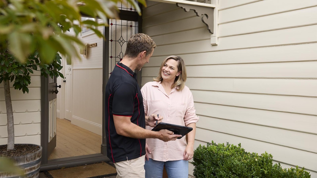 Building inspector and customer smiling while discussing a potential report.